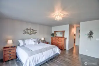 spacious main-floor primary suite with warm wood tones and serene coastal inspired charm