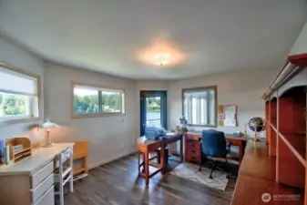 bright main floor bedroom turned office with natural light, built-ins and water views for inspired productivity