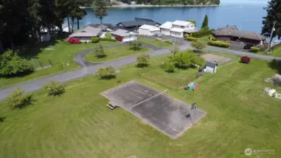 spacious community area with sport court, picnic bench and open green space perfect for play gatherings and recreation