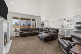 View of the great room, overlooking the living room, kitchen, dining area and access to exterior porch and backyard.