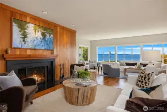 Warm Teak Hardwood flooring, walls of windows and wood-burning fireplace at center stage.