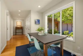 The interior breezeway connecting the guest area and primary suite offers casual dining overlooking center courtyard gardens.