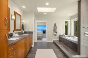 Beautiful primary bath with double vanity, skylights, heated floors, relaxing soaking tub and step-in shower.
