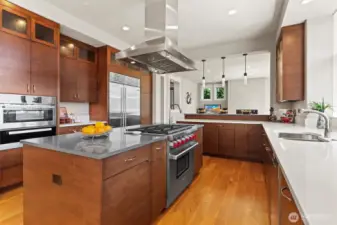 Large chef’s island kitchen with breakfast bar is equipped with top-tier Wolf, Miele, and SubZero appliances & walk-in pantry