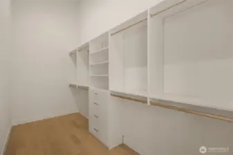 Boutique-style walk-in closet with custom shelving.