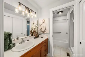 Primary bathroom the vanity and toilet and tub shower are divided by a pocket door. There is also a linen closet that is quite large on the wall  to the east if the vanity