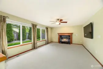 Family room  Cozy gas fireplace with fluted wood mantle and granite surround  Ceiling fan / picture windows