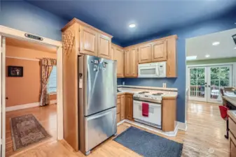 Kitchen looking to the dining room and great room with French doors leading to the back covered deck that can be utilized as part of your entertaining area.