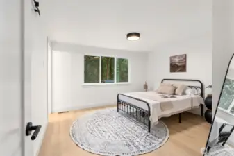 Primary bedroom on main level has lots of space and natural light.
