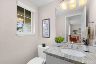 Downstairs powder bathroom off of the entrance with granite counters