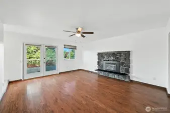 Primary bedroom with fireplace and french doors to the deck