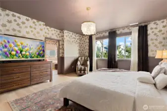 The primary suite offers a moody, color-drenched retreat with elevated design details throughout. Enter through a charming barn door into a private nook before stepping through the double-door entry into the spacious bedroom. Wainscoting and leaf-patterned wallpaper create warmth and texture, while newly added window casings enhance the tailored finish. A statement chandelier from Pottery Barn adds a soft glow and timeless elegance, perfectly complementing the room’s luxurious yet cozy vibe. It’s a restful haven designed with both beauty and serenity in mind.