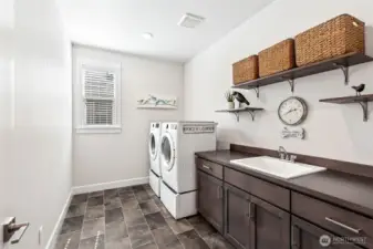 Large laundry room with shelving and 76" counter and deep laundry sink.