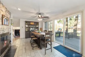 Enjoy cozy meals by the brick fireplace in this light-filled dining space. Large slider opens to the deck and serene outdoor setting, creating effortless indoor–outdoor living. Perfect blend of comfort, charm, and functionality.