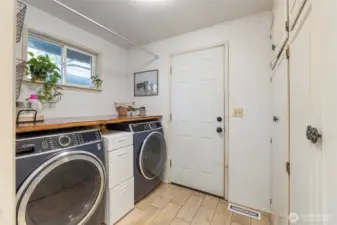 The laundry area located just off of the kitchen. Cupboards provide additional pantry storage.
