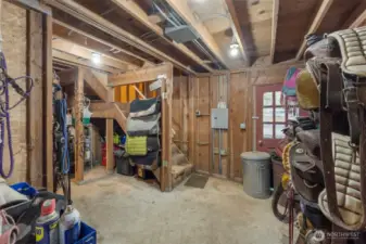Large tack room located at the end of the isle way offers lots of space. A stairwell leads up to the hayloft as well as a heated room for an office or additional storage.