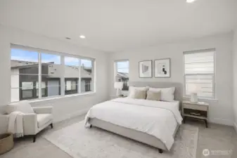 The primary suite is light and inviting, with large windows that fill the space with natural light and an airy feel.