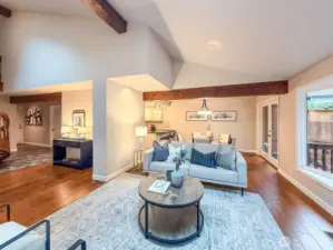 An open-plan space seamlessly blends the living room, dining area, kitchen, and a tucked-away half bath