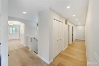 Bright, light and wide hallways. with all new European wide plank flooring.  The first open door on the left is the new power room, and the second door is the convenient laundry room. The furthest door on the left is the office with the primary suite at the end on the right.