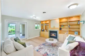 Comfortable library with custom built-in shelves, gas fireplace, and new European wide-plank flooring.  The new French doors lead to a covered patio overlooking the pastures and mountain views.