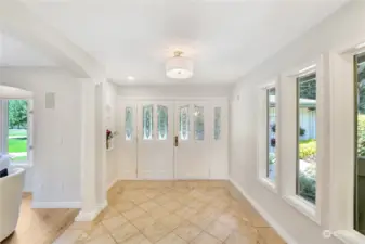 Double door entry opens to a large foyer, with windows for natural light.
