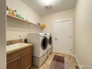 Utility sink and vanity; Shelf with rod; Door to the garage. Washer and dryer convey.