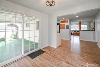 Dining room view looking back to kitchen and family room with sliding door leading to covered patio