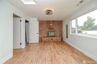 Here is view of the bonus/media room with floor to ceiling brick wood fireplace and large new vinyl windows to enjoy