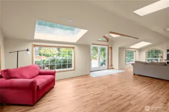 The beautiful sunroom/family room, updated flooring and French doors leading to the back deck.