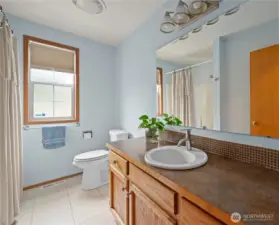 Spacious guest bath with tiled flooring.