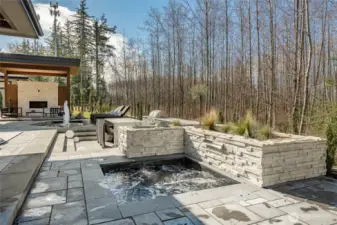 Built-in hot tub, 7x7, with custom water fountain off your primary bedroom. Your covered gazebo includes gas fireplace looking out onto your beautiful designed water feature.