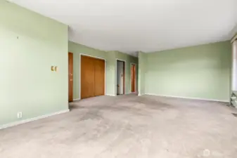 Looking from the large front window to the dining area and beyond to the rear of the unit - first open door is the basement stairway, second open door with the light on is the bathroom