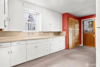 Generous kitchen with amazing cabinet and counter space!  Bifold doors are the washer and dryer, rear door leads to the deck and back yard