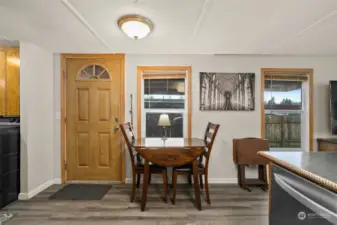 Back door off kitchen, leading to covered deck, and fenced backyard.