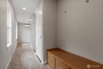 W/D closet next to built in bench with storage