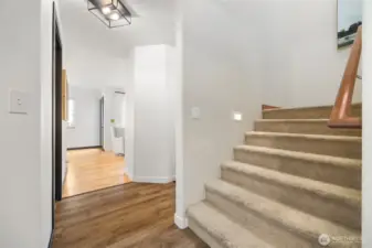 The wide stairway to the bedrooms and full baths has additional lighting.