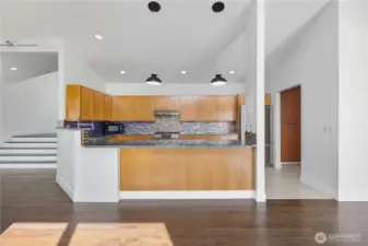 Chef’s Kitchen -   Stylish and functional kitchen with stainless steel appliances, sleek tile backsplash, and pendant lighting over spacious counters.