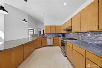 Chef’s Kitchen -  Modern kitchen layout with extended counter space, pendant lighting, and a bar-style peninsula perfect for entertaining guests.