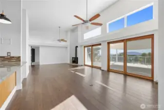 Great Room -   Open-concept living area with wall-to-wall glass doors leading to the deck — blending indoor comfort with outdoor beauty.