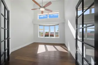 Office -   Bright and inspiring home office with French doors, vaulted ceilings, and large windows framing scenic views — ideal for remote work or a creative studio.