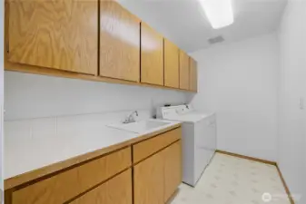 Laundry Room -   Dedicated laundry space with built-in cabinetry, deep utility sink, and plenty of counter space for everyday convenience.