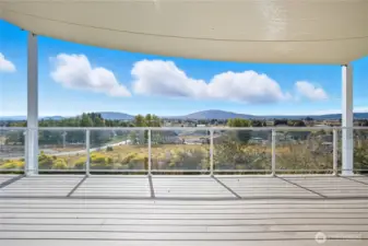 Patio (Alternate View)  The spacious back patio and deck area provide multiple outdoor zones for entertaining or relaxing, framed by lush greenery and stunning views.