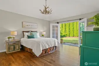 Exquisite primary suite with double French doors to the back patio and yard complete with roses and blueberries!