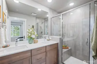 Primary bath. Shower with floor to ceiling title, built in bench and designer tile accents with inset shelf. Photos are of model home in the community.