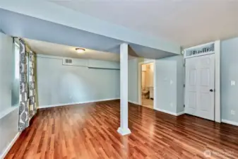 Living space in lower level showing entrance to 3/4 bath.
