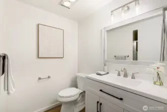¾ en-suite bath with updated vanity, lighting, and fixtures.