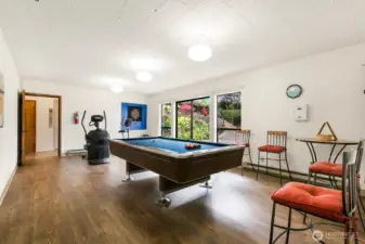 Bright community space with pool table, exercise area, and lounge seating.