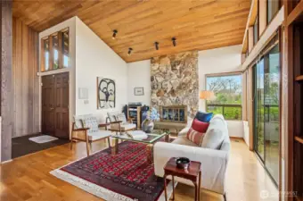 Living room features grand rhyolite stone fireplace - view to the front entry