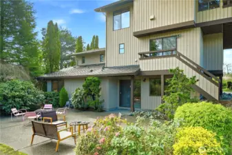 View of the rear of the house with large private patio with sliders from the lower level den