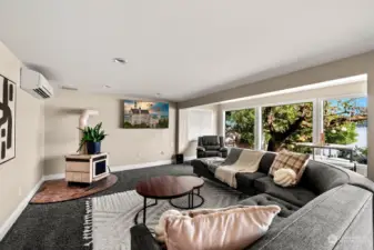 Lower level living room features a wet bar, ductless heat and a/c, wall of windows, and so much space!